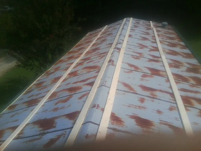 Rusted metal roof panels with new wood purlins before replacement — Storm Damage Roof Repair in Byers by Roofing Brothers